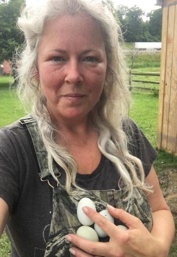 profile photo of Michelle, owner operator of Green Goose Farm with eggs in her hands